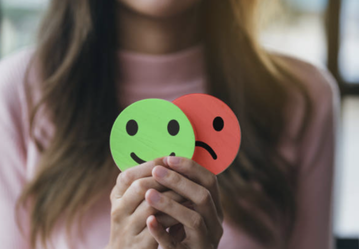 bpd vs bipolar featured image woman holding emojis